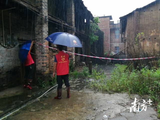黨群志愿者冒雨拉起警戒線。